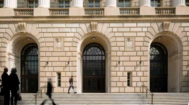 People walk by the Internal Revenue Service building